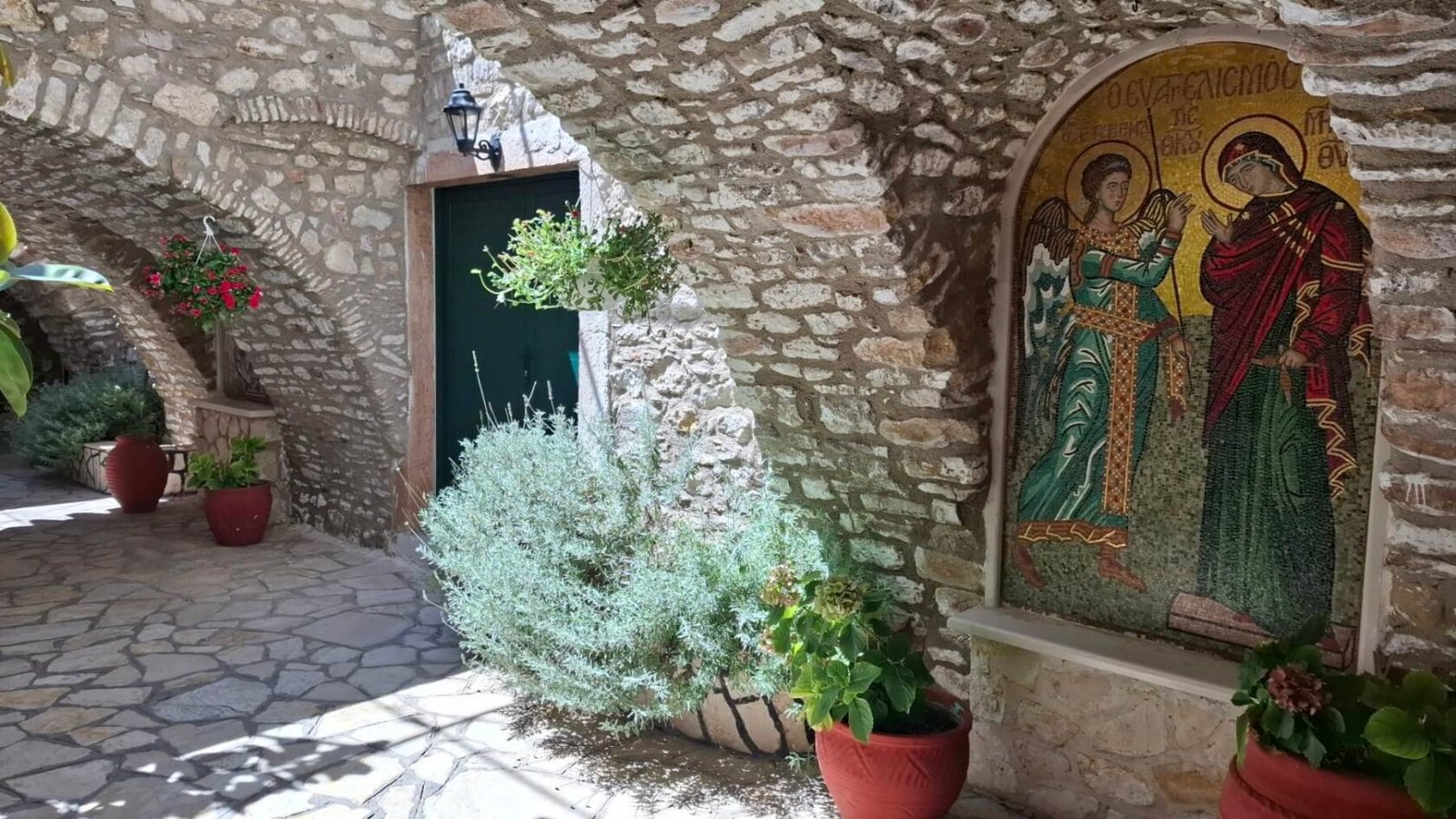 Stone-paved courtyard with arches and a mosaic depicting the Annunciation of the Theotokos, of the Holy Monastery of Paleokastritsa